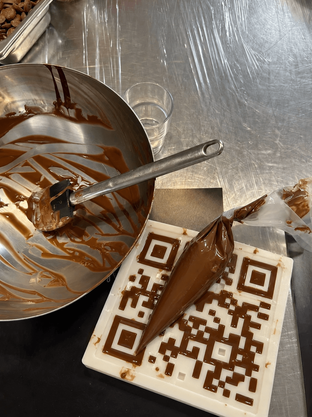 Molde del QR con chocolate y manga pastelera sobre la encimera